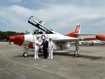 Capt. Daniel Ouimette, Commodore, Training Air Wing One (TW-1), left, presents the last T-2C Buckeye.