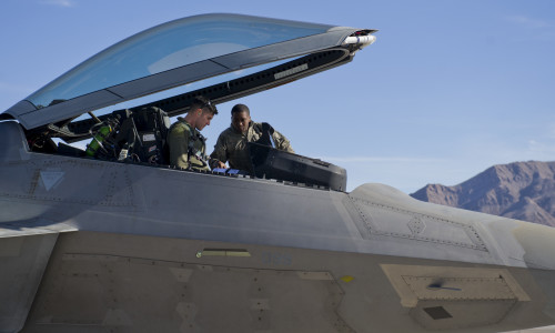 Major Scott Crowell, 325th Operations Group F-22 Raptor pilot, and Senior Airmen Eric Woods, 95th Aircraft Maintenance Unit crew chief, talk before Crowell takes flight on the first day of Red Flag 16-1, Jan. 25, at Nellis AFB, Nev. Integration is key at Red Flag, and Tyndall’s F-22s and Airmen join more than 130 aircraft and 3,000 personnel training during the exercise.