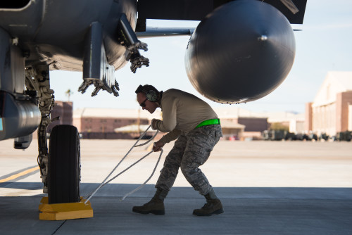 Senior Airman Aaron Wilson, a crew chief assigned to the 4th Fighter Wing, Seymour Johnson Air Force Base, N.C., places parking chocks against the tire of an F-15E Strike Eagle during pre-flight checks as part of Red Flag 16-1, Jan. 25, 2016. Red Flag is a realistic combat training exercise involving the air, space and cyber forces of the U.S. and its allies, and is conducted on the vast bombing and gunnery ranges on the Nevada Test and Training Range.