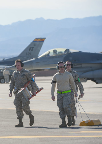 Crew members from Seymour Johnson Air Force Base, N.C., carry equipment away after working on an F-15E during Red Flag 16-1, Jan. 25, 2016, at Nellis Air Force Base, Nev. Red Flag is celebrating its 41st anniversary with Red Flag being a realistic combat training exercise involving the air, space and cyber forces of the U.S. and its allies, and is conducted on the vast bombing and gunnery ranges on the Nevada Test and Training Range. (U.S. Air Force photo by Senior Airman Jake Carter)