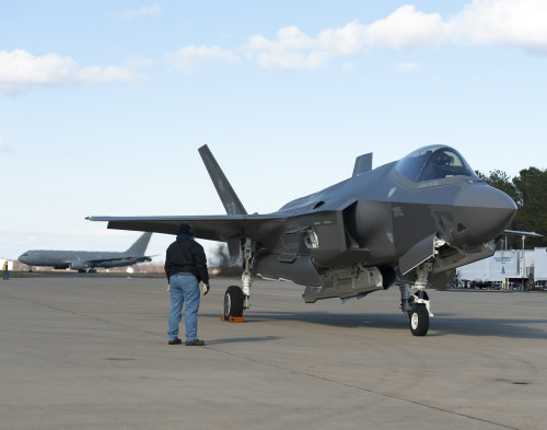 160205-O-ZZ999-923 NAS Patuxent River (February 5, 2016) A member of the Pax River Integrated Test Force (ITF) stands at the ready as Italian Air Force (Aeronautica Militare) aircraft AL-1 — the first F-35 Lightning II international jet fully built overseas at the Cameri Final Assembly & Check-Out (FACO) facility at Cameri Air Base, Italy, — arrives at the Navy’s Electromagnetic Environmental Effects (EEE) test and evaluation laboratory aboard Naval Air Station (NAS) Patuxent River on Feb. 5, 2016. (U.S. Navy photo courtesy Andy Wolfe/Released)