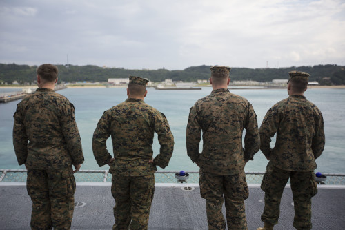 Four Marines with the 31st Marine Expeditionary Unit watch from the flight deck of the USS Bonhomme Richard (LHD 6) as it pulls out of port at White Beach, Okinawa, Japan, Feb. 6, 2016. The Marines and sailors of the 31st MEU and the Bonhomme Richard Amphibious Ready Group are currently on their spring deployment to the Asia-Pacific region. (U.S. Marine Corps photo by Gunnery Sgt. Zachary Dyer/Released)