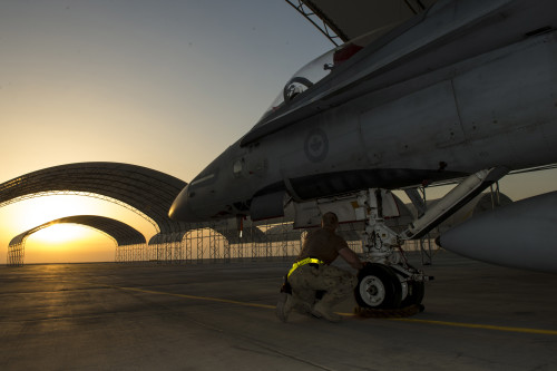 An aircraft technician from Air Task Force – Iraq inspects the nose landing gear of a CF-188 Hornet aircraft at the Camp Patrice Vincent flight line, in Kuwait during Operation IMPACT on December 11, 2015. Photo: OP IMPACT, DND KW02-2015-0397-004 