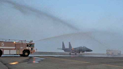 Fire engines from the 380th Expeditionary Civil Engineer Squadron render a water salute to a taxing F-15E Strike Eagle fighter aircraft at an undisclosed location in Southwest Asia, April 9, 2016. The water salute is used for to celebrate various achievements of aircrew personnel, aircraft and in this case, reaching the 1,000 combat flight hour milestone during a mission. (U.S. Air Force photo by Staff Sgt. Kentavist P. Brackin/Released)