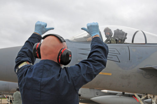 U.S. Air Force and Massachusetts Air National Guard crew chief Tech Sgt. Darius Zienkiewicz signals to pilot Maj. Eric Armentrout that the aircraft, an F-15C Eagle, is chalked.  Maj. Armentrout is returning from a Frisian Flag 2016 exercise mission, April 19, 2016. Frisian Flag 2016 is a Royal Netherlands Air Force multilateral training exercise designed to foster military cooperation between member nations.