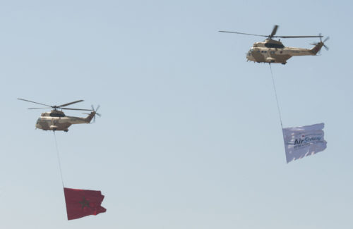The Royal Moroccan flag and the International Marrakech Airshow flag are flown over the airfield during the opening day ceremony in Marrakech, Morocco on Apr. 27, 2016. Several United States, independent and government owned aircraft were displayed at the expo in an effort to demonstrate their capabilities to a broad audience of individuals from approximately 54 other countries. (DoD News photo by TSgt Brian Kimball)