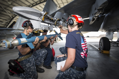 US Navy AO1 Michelle Toth directs armament technicians during the loading of ordnance onto VFA-115 F/A-18E Super Hornets at a media launch for Exercise Black Dagger.[/caption]

[caption id=