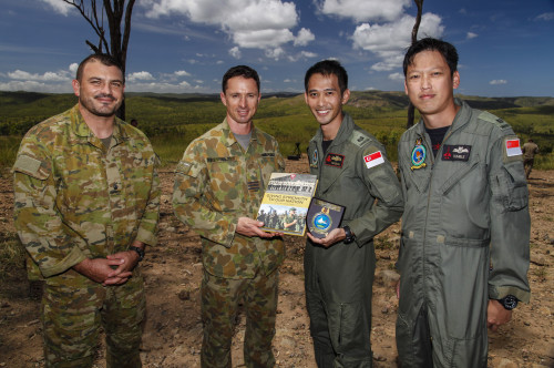 Royal Australian Air Force officer Wing Commander Harvey Reynolds (centre left), AM, Commanding Officer of 4 Squadron, accepts a plaque from Major Damien Tan (centre right) and Major Wee Tumble (right), both from the Republic of Singapore Air Force, watched on by Australian Army officer Major Ross Wehby (left) during Exercise Black Dagger near Townsville, Queensland, on 6 April 2016.[/caption]

[caption id=