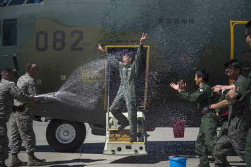 Japanese Air Defense Force Chief Master Sgt. Takanori Konishi, with the 401st Squadron, 1st Tactical Airlift Wing in Japan celebrates after completing the milestone of 10,000 C-130 Hercules flight hours on June 15, 2016, at Joint Base Elmendorf-Richardson, Alaska. A rare milestone, Konishi has spent a little over 416 days flying in the C-130. (U.S. Air Force photo by Senior Airman James Richardson/Released)