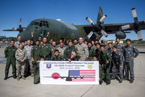 U.S. Air Force and Japanese Air Defense Force Airmen pose for a celebratory photo for Chief Master Sgt. Takanori Konishi, with the 401st Squadron, 1st Tactical Airlift Wing after he completed the milestone of 10,000 C-130 Hercules flight hours on June 15, 2016, at Joint Base Elmendorf-Richardson, Alaska. A rare milestone, Konishi has spent a little over 416 days flying in the C-130. (U.S. Air Force photo by Senior Airman James Richardson/Released)