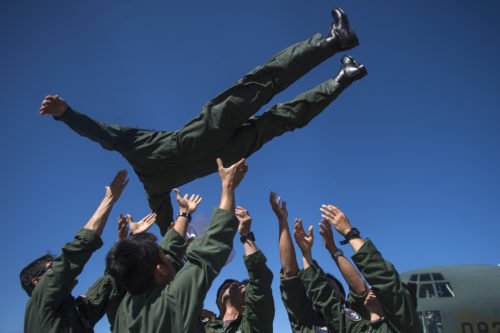 Japanese Air Defense Force Chief Master Sgt. Takanori Konishi, with the 401st Squadron, 1st Tactical Airlift Wing in Japan is thrown into the air as he celebrates completing the milestone of 10,000 C-130 Hercules flight hours on June 15, 2016, at Joint Base Elmendorf-Richardson, Alaska. A rare milestone, Konishi has spent a little over 416 days flying in the C-130. (U.S. Air Force photo by Senior Airman James Richardson/Released)