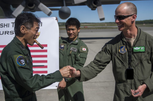 U.S. Air Force Chief Master Sgt. Bryant Roy, poses for a celebratory photo for Chief Master Sgt. Takanori Konishi, with the 401st Squadron, 1st Tactical Airlift Wing after he completed the milestone of 10,000 C-130 Hercules flight hours on June 15, 2016, at Joint Base Elmendorf-Richardson, Alaska. A rare milestone, Konishi has spent a little over 416 days flying in the C-130. (U.S. Air Force photo by Senior Airman James Richardson/Released)
