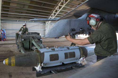 U.S. Marine Corps Lance Cpl. Trevor Serenelli, ordnance Marine assigned to Marine Fighter Attack Squadron (VMFA) 122, helps U.S. Marine Corps Cpl. Blake Uhden, ordnance Marine assigned to VMFA-122, guide a bomb onto an aircraft during Southern Frontier at Royal Australian Air Force Base Tindal, Australia, Aug. 26, 2016. VMFA-122 dropped hundreds of thousands of pounds of ordnance while conducting close air support missions for ground combat units at the Bradshaw Range Complex. Southern Frontier is a three week unit level training evolution helping the flying squadron gain qualifications and experience in low altitude, air ground, high explosive ordnance delivery. (U.S. Marine Corps photo by Cpl. Nicole Zurbrugg)