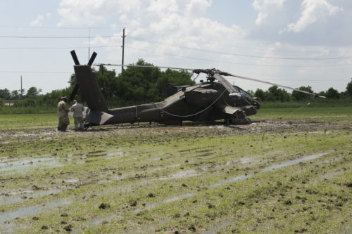 Texas Guardsmen prepare an AH-64D Apache helicopter for recovery operations using a universal maintenance aviation recovery kit, September 1, 2016, following a precautionary landing in a rice paddy in Wallisville, Texas, near Houston, due to mechanical issues. Maintenance soldiers from the 1st Battalion, 149th Aviation Regiment (Attack Reconnaissance) waded through six-inch deep mud and worked in a heat index of more than 100 degrees, to ensure a safe and successful sling load recovery mission. (U.S. Army National Guard photo by Capt. Martha Nigrelle)