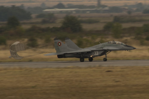 A Bulgarian air force Mikoyan MiG-29 Fulcrum fighter aircraft assigned to the 3rd Air Force Base flies releases its parachute during a landing on the flightline during joint NATO air policing at Graf Ignatievo, Bulgaria, Sept. 8, 2016. Four California and Massachusetts Air National Guards’ F-15C Eagle fighter aircraft and approximately 75 Airmen from the 194th Expeditionary Fighter Squadron deployed to Graf Ignatievo, Bulgaria, and will stand ready as interceptors, prepared to quickly react to any violations and infringements for policing of Bulgarian airspace Sept. 9-16, 2016. The squadron forward deployed to Graf Ignatievo from Campia Turzii, Romania, where they serve on a theater security package deployment to Europe as a part of Operation Atlantic Resolve.  (U.S. Air Force photo by Staff Sgt. Joe W. McFadden/Released)