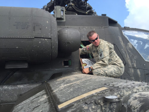 Texas Army National Guard Maj. Rawn Wilson, inspects an AH-64D Apache helicopter, September 1, 2016, following a precautionary landing in a rice paddy in Wallisville, Texas, near Houston, due to mechanical issues. Maintenance soldiers from the 1st Battalion, 149th Aviation Regiment (Attack Reconnaissance) waded through six-inch deep mud and worked in a heat index of more than 100 degrees, to ensure a safe and successful sling load recovery mission. (U.S. Army National Guard photo by Capt. Martha Nigrelle)