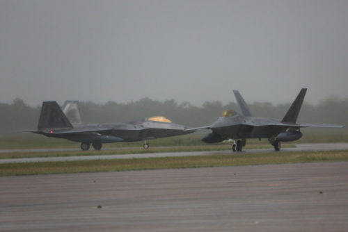 Two United States Air Force F-22 aircraft arrive at RAAF Base Tindal under grey skies and rain in the Northern Territory, ahead of the first Enhanced Air Cooperation activity in Australia. *** Local Caption *** The first group of USAF F22s arrived at RAAF Tindal ahead of the first Enhanced Air Cooperation activity in Australia under the US Force Posture Initiatives. The F22s will be located at RAAF Base Tindal and are the largest and longest rotation of fifth-generation aircraft to visit Australia to date. The F22s will conduct combined training activities with the Royal Australian Air Force's 75 Squadron F/A-18A/B Hornets along with ground assets and personnel.