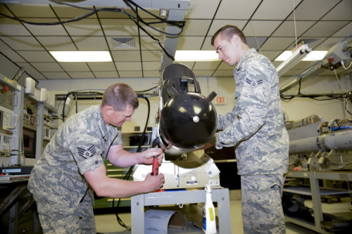 Staff Sgt. Derek Jaeger, 114th Maintenance Squadron electronic countermeasure technician, and  Airman 1st Class Duane Jongeling, 114th Maintenance Squadron electronic countermeasure apprentice, perform a routine maintenance on a electronic warfare pod. These pods are the first line of defense for the 114th Fighter Wing pilots while protecting foreign and domestic airspace. (U.S. Air National Guard photo by Staff Sgt. Duane Duimstra/Released)