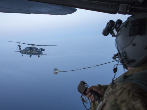 A U.S. Air Force loadmaster from the 353rd Special Operations Group observe a Japan Air Self-Defense Force UH-60J Black Hawk helicopter assigned to the Komatsu Air Rescue Squadron above the Sea of Japan, June 19, 2017, during Exercise Teak Jet. This is the first time that members of the 353rd SOG held HAAR training at night with JASDF members in Honshu Island in Japan. Exercise Teak Jet is a joint combined exchange training (JCET) focused on improving interoperability between U.S. Air Force and Japan Air Self-Defense Force. (U.S. Air Force photo by Yasuo Osakabe)