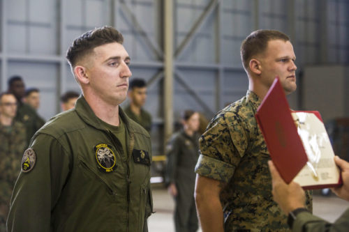 Sgt. Ethan Mintus and Sgt. Joseph Latsch, both unmanned aerial system (UAS) operators with Marine Unmanned Aerial Vehicle Squadron 3 (VMU-3), wait to be awarded during a ceremony at Hangar 103, Marine Corps Air Station Kaneohe Bay, Dec. 11, 2017. They were awarded the Navy and Marine Corps Achievement Medal with the newly authorized Remote Impact (“R”) Device for their performance during combat operations. (U.S. Marine Corps photo by Lance Cpl. Isabelo Tabanguil)