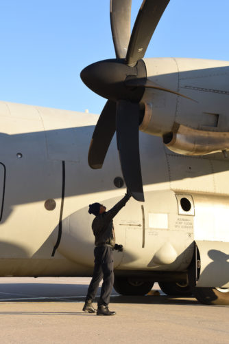 An Indian Air Force crew member manually rotates the propellers of a C-130 Hercules Jan. 13, 2018, after landing at Grand Forks Air Force Base, N.D. before heading to McChord AFB, Wash. for exercise Vajra Prahar. (U.S. Air Force photo by Airman 1st Class Elora J. Martinez)
