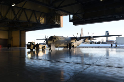 Grand Forks Airmen and service members with the Indian Air Force work together to tow a C-130 Hercules into a hangar Jan. 13, 2018, on Grand Forks Air Force Base, N.D. The Indian service members transited through Grand Forks AFB and received routine maintenance before heading to McChord AFB, Wash. for exercise Vajra Prahar. (U.S. Air Force photo by Airman 1st Class Elora J. Martinez)