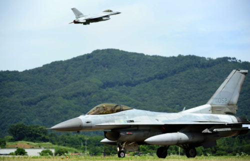 A KF-16 Fighting Falcon from the 19th Fighter Wing taxis as another takes off of the runway at Jungwon Air Base, Republic of Korea, during Buddy Wing 15-6, July 10, 2015. In an effort to enhance U.S. and ROKAF air combat capability, Buddy Wing exercises are conducted multiple times throughout the year on the peninsula to sharpen interoperability between the allied forces so that if need be, they are always ready to fight as a combined force. (U.S. Air Force photo by Staff Sgt. Nick Wilson/Released)